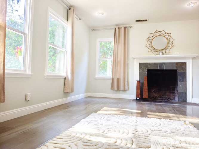 A living room with a fireplace and a mirror on the wall.
