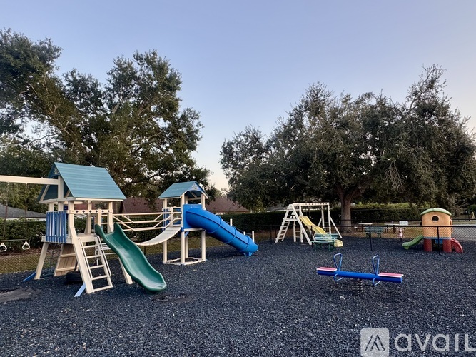 A playground with a blue slide and a green slide.
