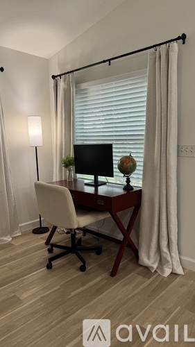 A desk with a chair and a lamp in a room.