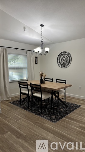 A dining room with a wooden table and chairs.