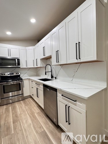 A kitchen with white cabinets and a stainless steel oven.