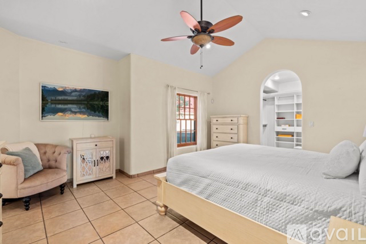 A bedroom with a bed, dresser, and a painting on the wall.