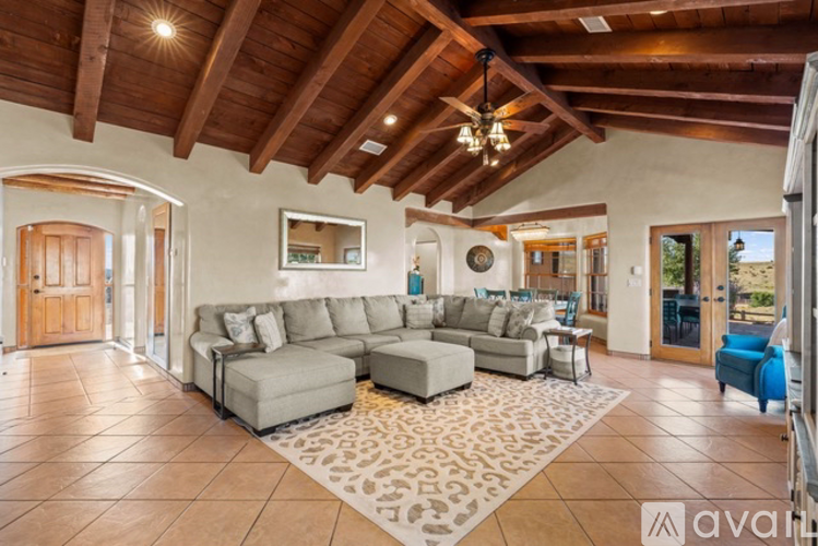 A spacious living room with a large sectional sofa and a rug in the center.