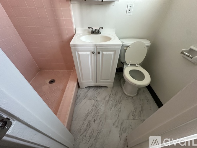 A white toilet sits next to a sink in a small bathroom.
