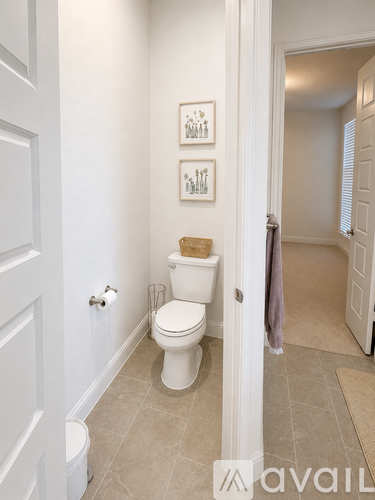 A white toilet with a brown seat cover in a bathroom.