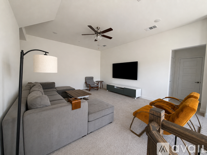 A living room with a grey sofa, a wooden table, and a television.
