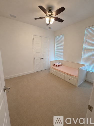 A room with a ceiling fan and a window with blinds.