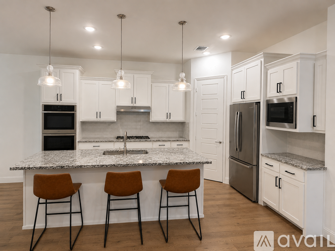 A kitchen with white cabinets and a granite countertop.