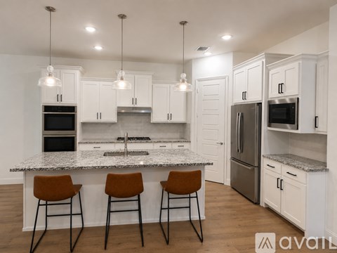 A kitchen with white cabinets and a granite countertop.