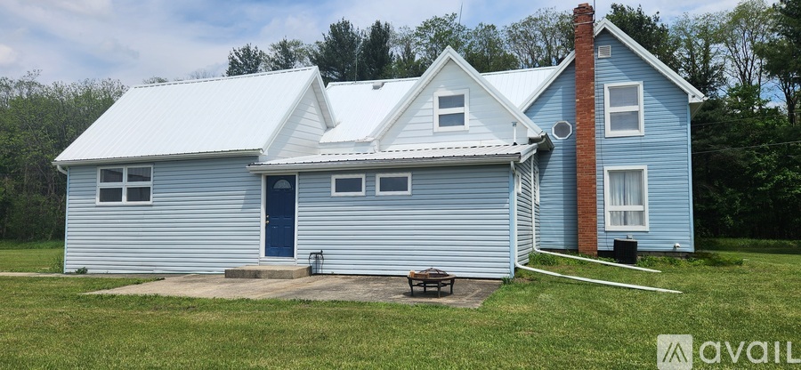 A blue house with a white roof and a chimney.