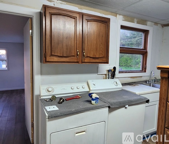 A white oven and stove top are in a kitchen with wooden cabinets.