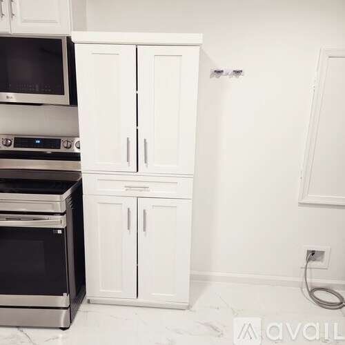 A kitchen with white cabinets and a stainless steel oven.