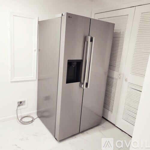 A stainless steel refrigerator with a black interior and a handle on the door.