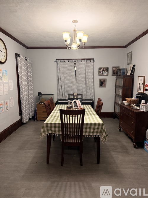 A dining room with a checkered tablecloth and chairs.