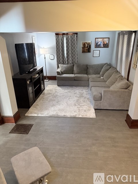 A living room with a grey couch and a television.