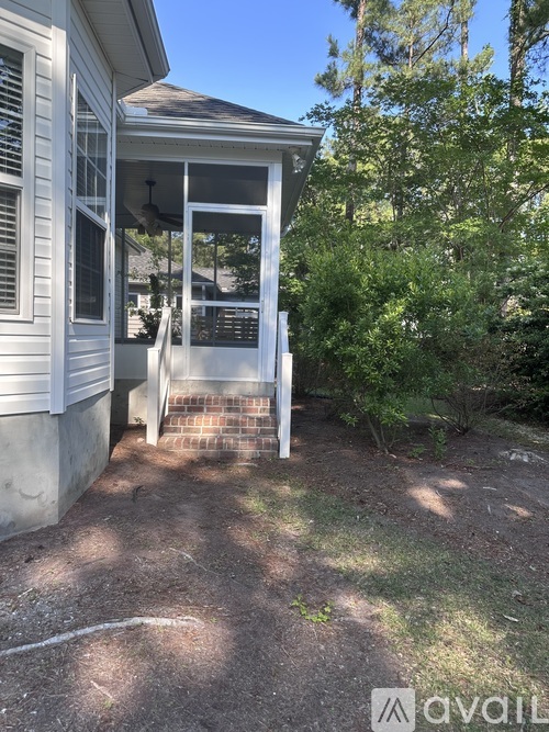 A house with a white exterior and a screened porch.