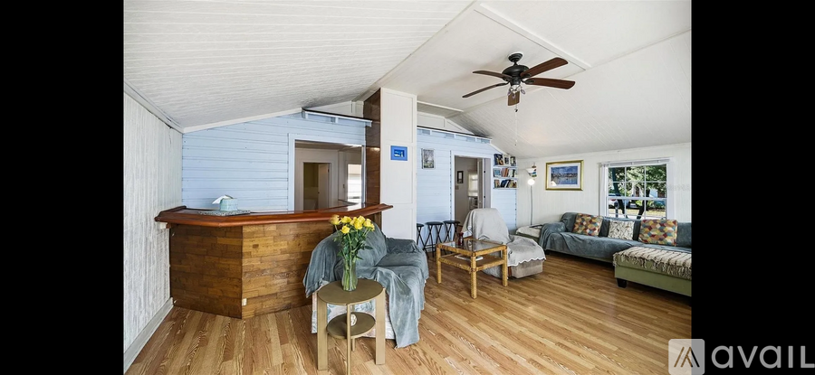 A living room with a wooden floor and a ceiling fan.