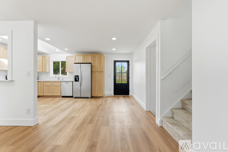 A kitchen with wooden floors and white walls.