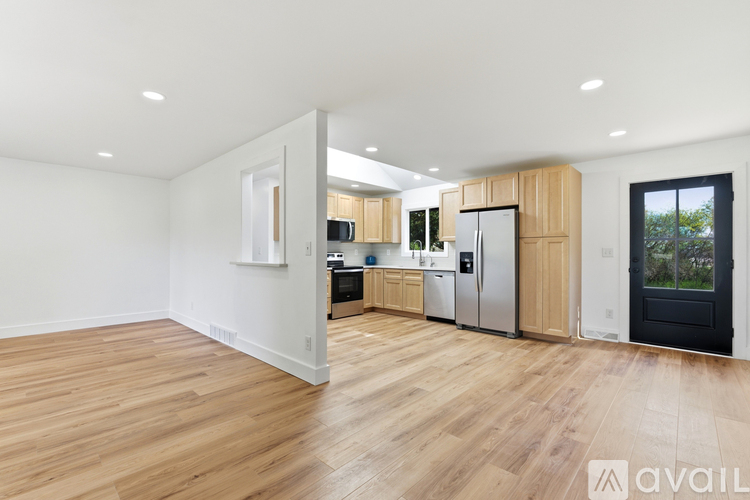 A kitchen with wooden floors and stainless steel appliances.