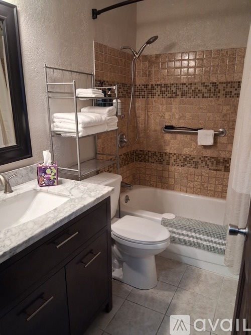 A bathroom with a toilet, sink, and shower.
