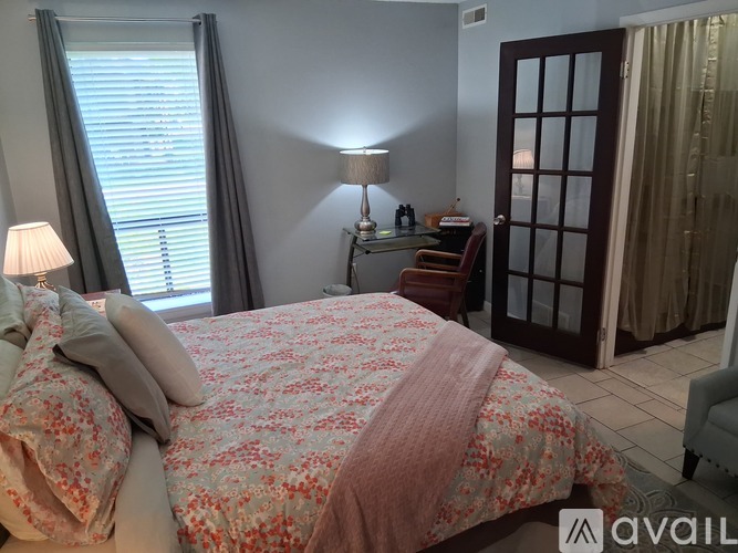 A bedroom with a bed, nightstand, and chair.