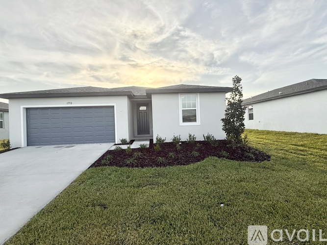 A modern house with a grey garage door is for sale.
