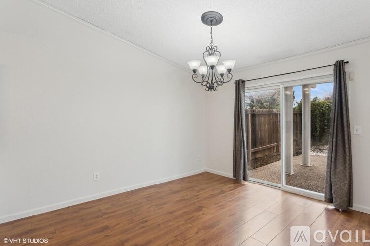 A room with wooden floors and a chandelier hanging from the ceiling.