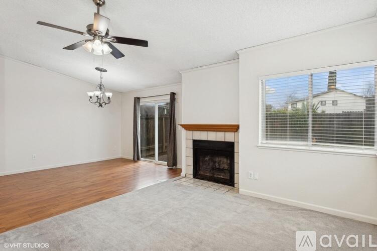 A living room with a fireplace and a ceiling fan.