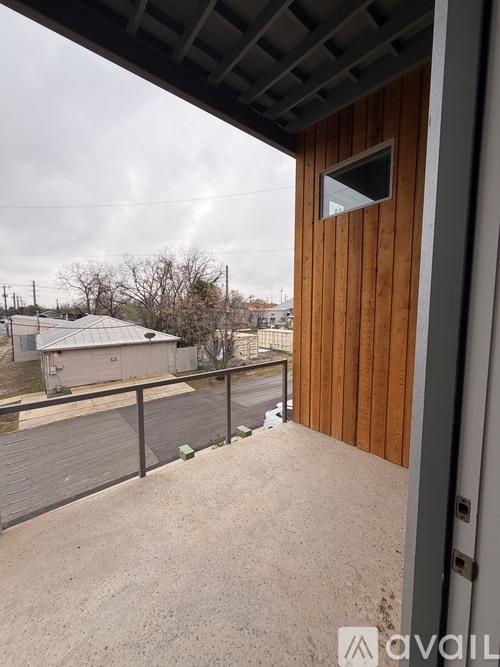A balcony with a wooden door and a metal railing.