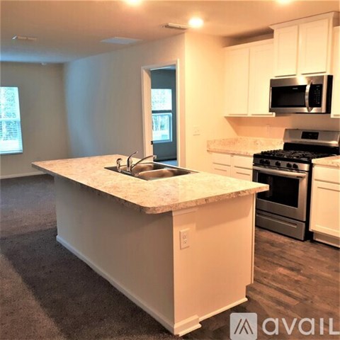 A kitchen with a granite countertop and white cabinets.
