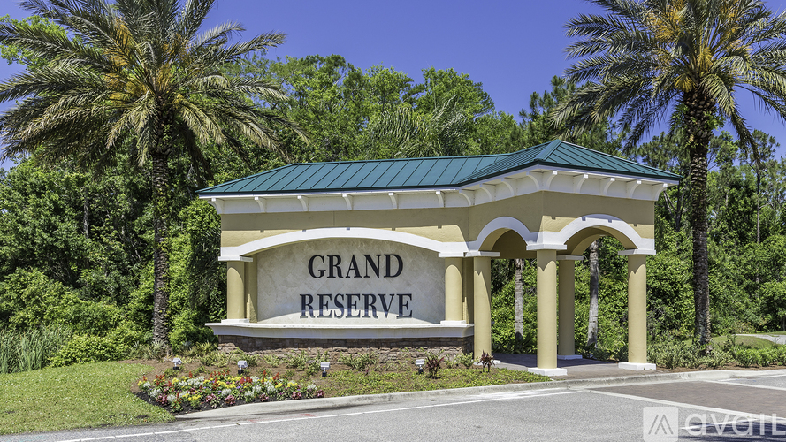 A sign that says Grand Reserve stands in front of some trees.