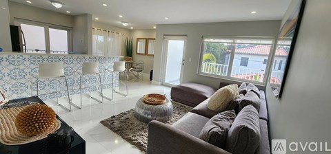 A living room with a grey couch and a black coffee table.