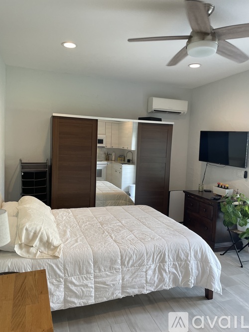 A bedroom with a large bed and a ceiling fan.