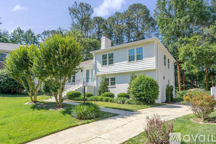 A white house with a green lawn in front.