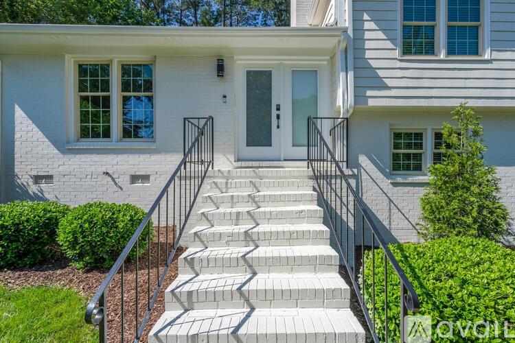 A white house with a grey staircase leading to the front door.
