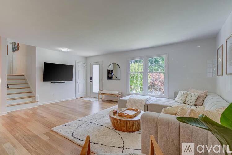 A living room with a couch, a coffee table, and a television.