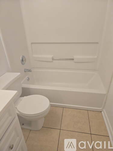 A white toilet sits next to a bathtub in a bathroom.