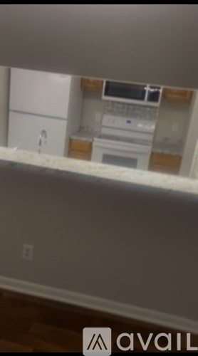 A kitchen with a white counter top and a white fridge.