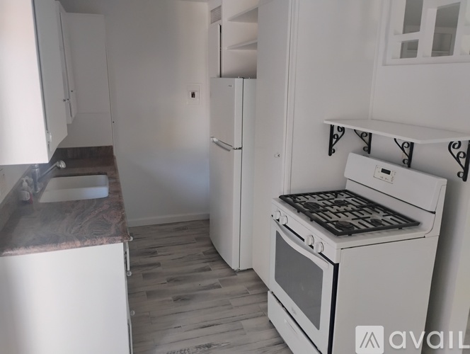 A kitchen with a white oven and a white fridge.