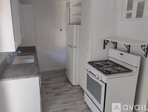 A kitchen with a white oven and a white fridge.