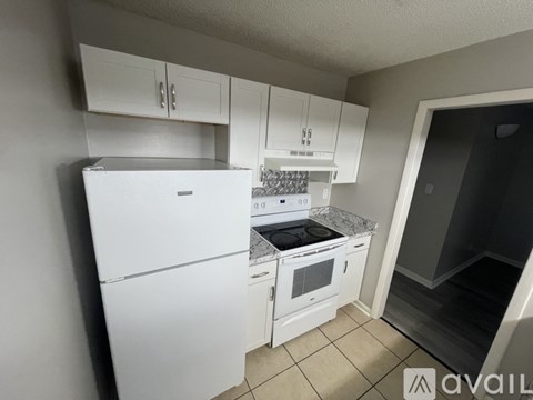 A kitchen with white appliances and cabinets.