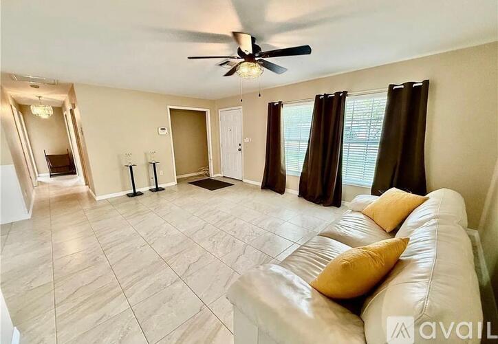A living room with a white couch and a ceiling fan.