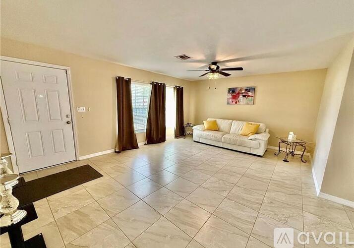 A living room with a white sofa and a ceiling fan.