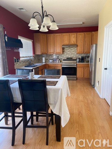 A kitchen with wooden cabinets and a table set for two.