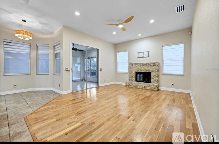 A spacious room with a fireplace and wooden flooring.