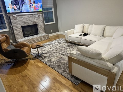 A living room with a white couch and a fireplace.