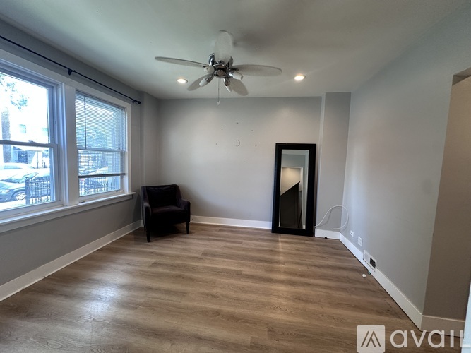 A room with a ceiling fan and a chair is available for rent.
