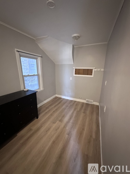 A room with a wooden floor and a window.