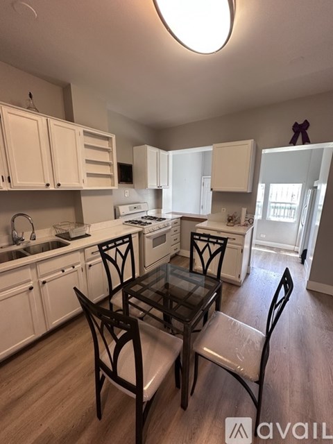 A kitchen with a table and chairs in the foreground.