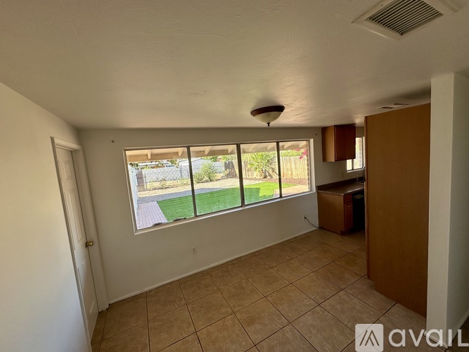 A room with a large window and a tiled floor.